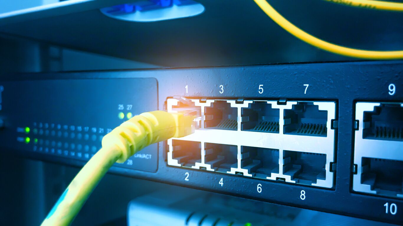 Network switch with a yellow patch cable plugged into a numbered port